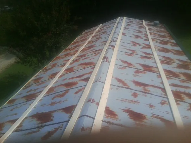 Rusted metal roof panels with new wood purlins before replacement — Storm Damage Roof Repair in Clarkton by Roofing Brothers