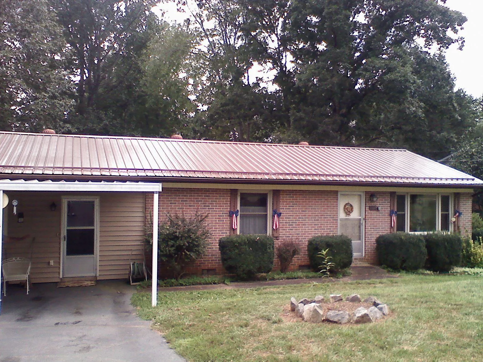 Bronze metal roof and carport on a brick ranch home — Roof Repair work by our crew in Clarkton